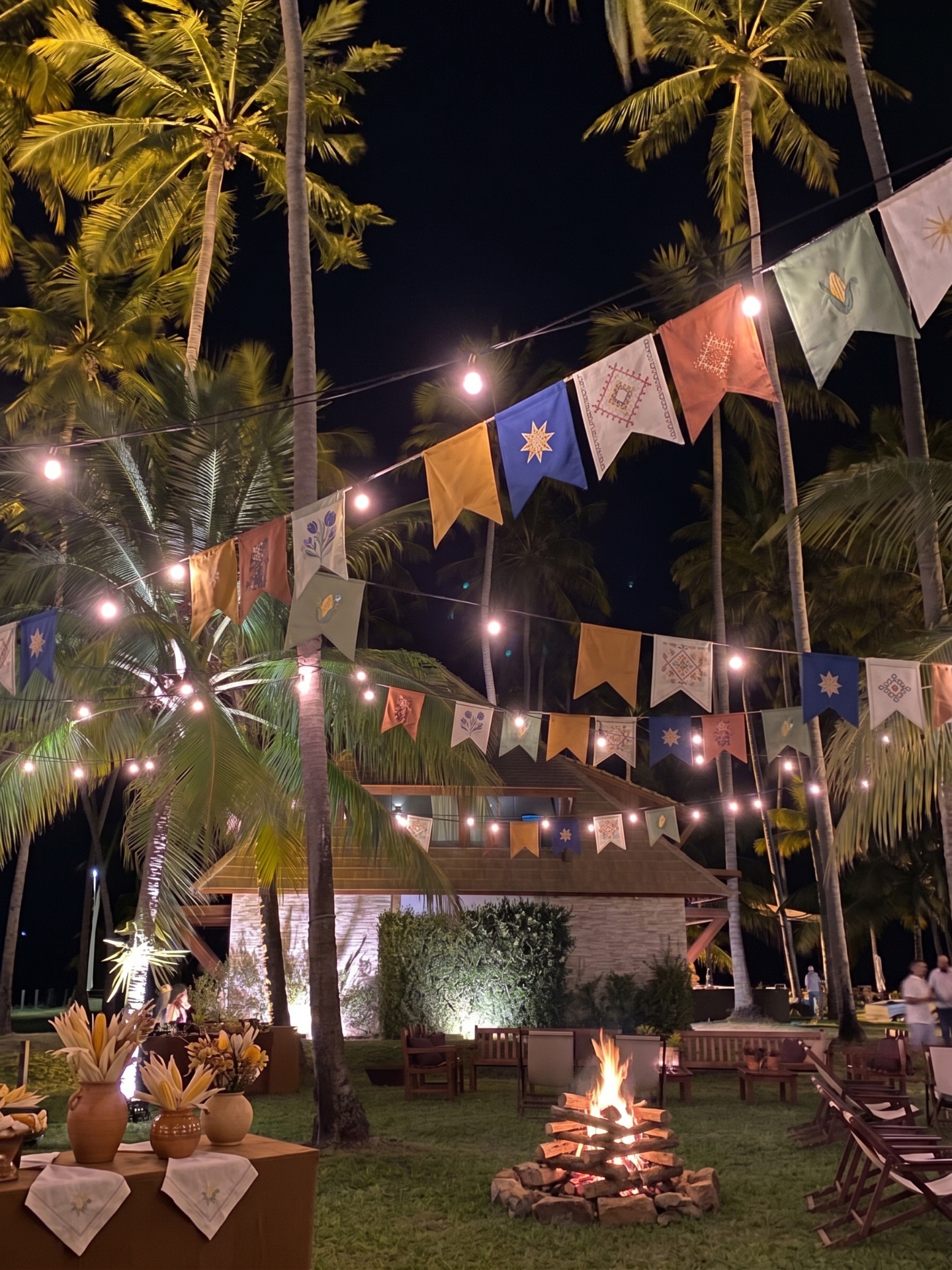 São João no Pontal — bandeirinhas, fogueira e coqueiral iluminado